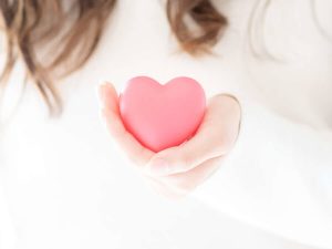 女性が手に持つピンクのハート