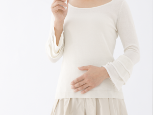 お腹をおさえる女性